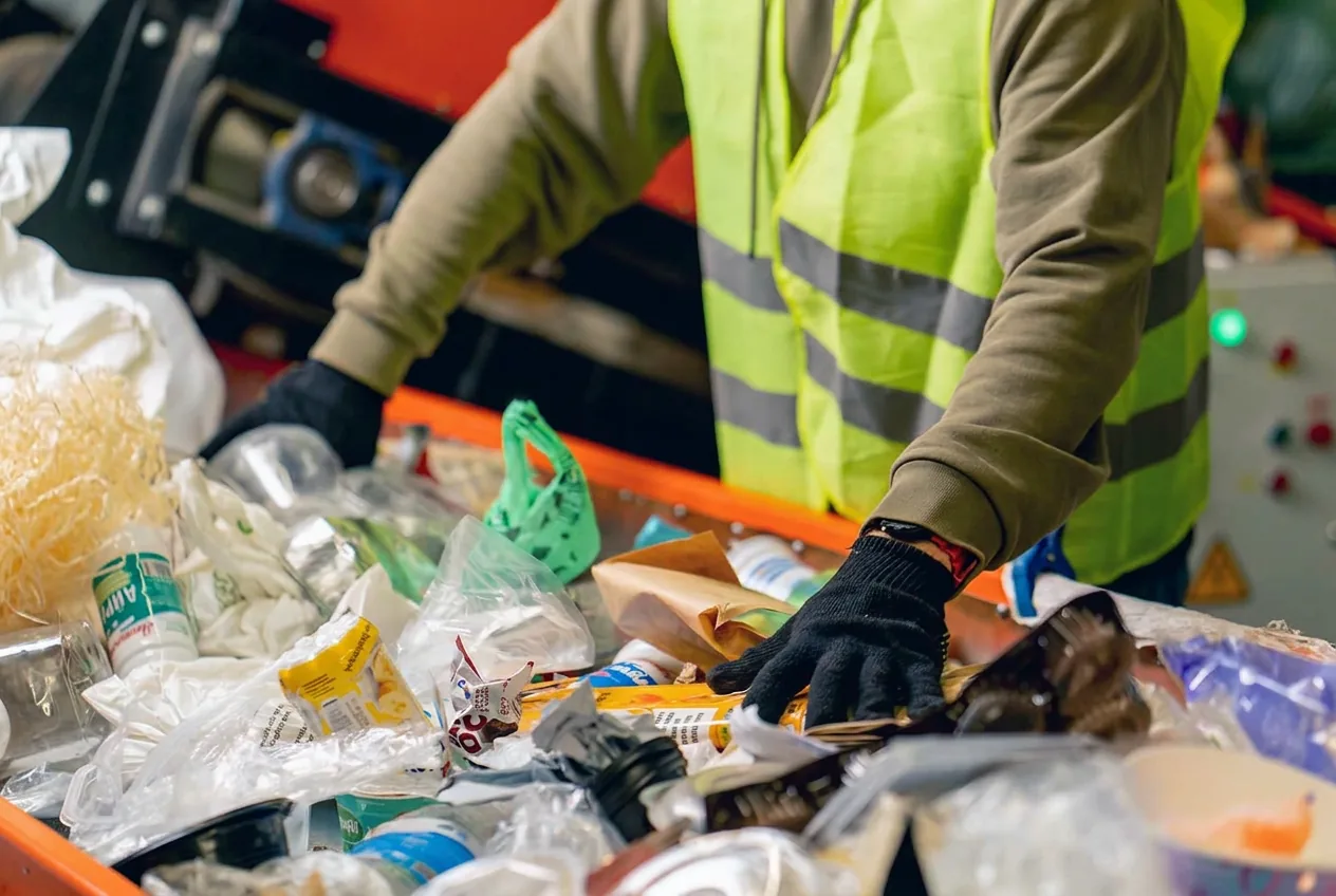 Trabalhador fazendo triagem de materiais recicláveis